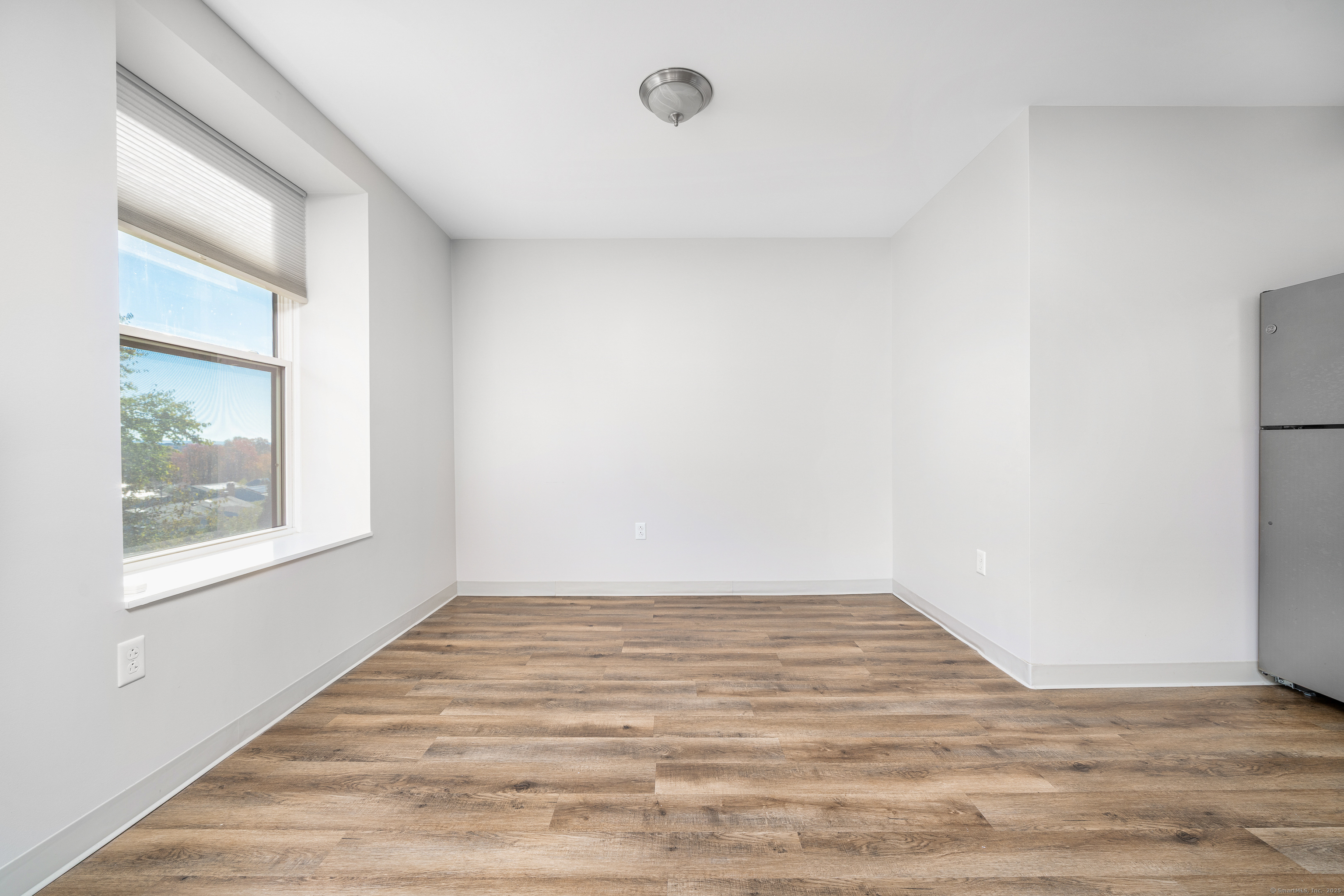 170 Ridge Road, Unit 201 Wethersfield, CT 06109 - Photo 7 of 25 a view of an empty room with wooden floor and a window