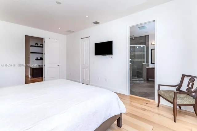 a bedroom with a bed and wooden floor