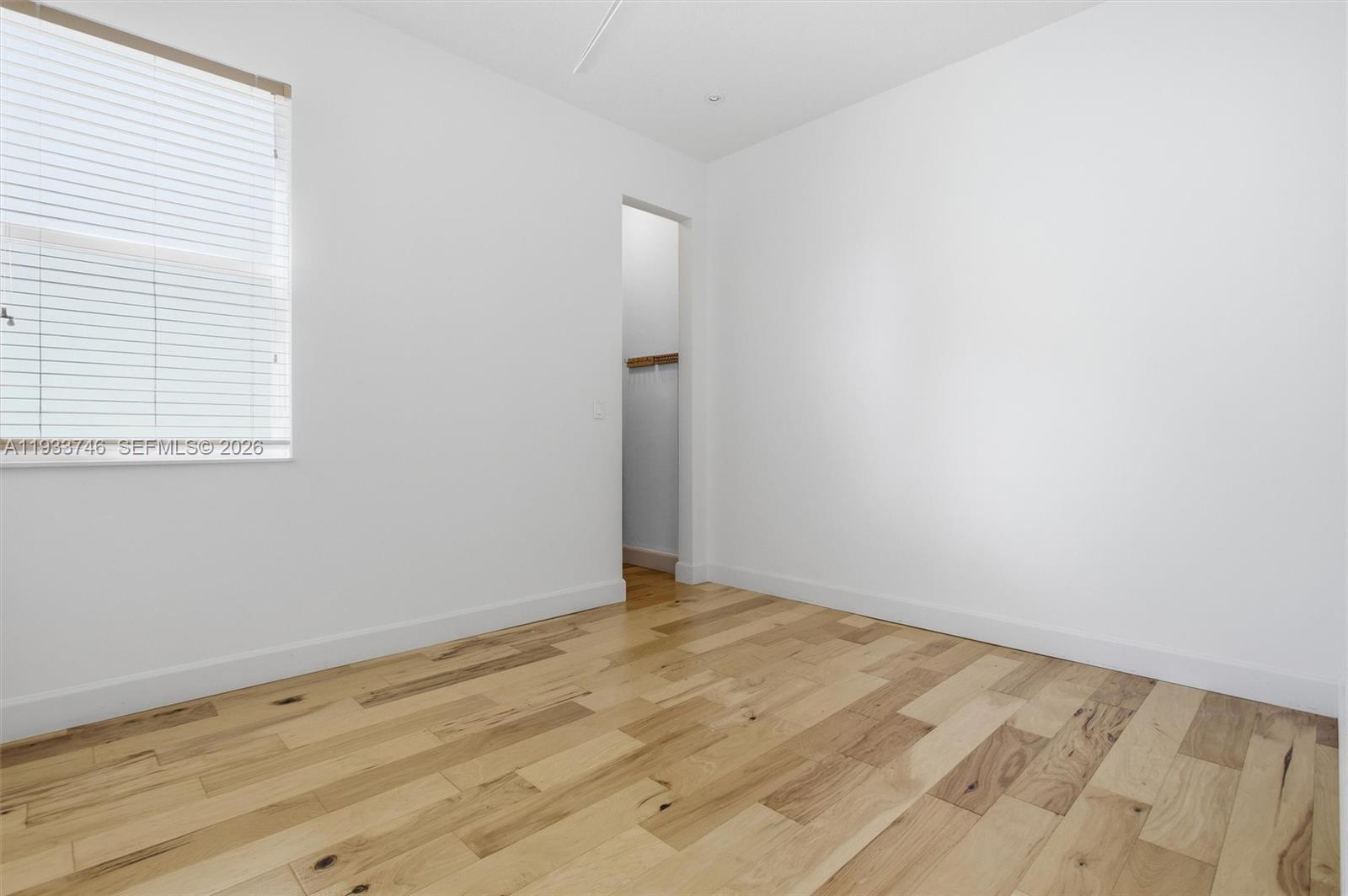 4857 Northwest 16th Terrace Boca Raton, FL 33431 - Photo 27 of 45 an empty room with wooden floor and windows