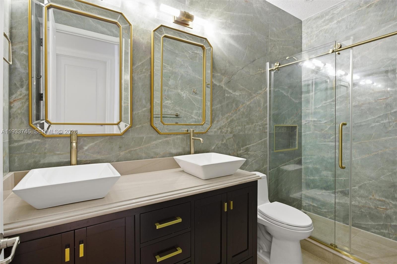 4857 Northwest 16th Terrace Boca Raton, FL 33431 - Photo 28 of 45 a bathroom with a double vanity sink toilet and a mirror