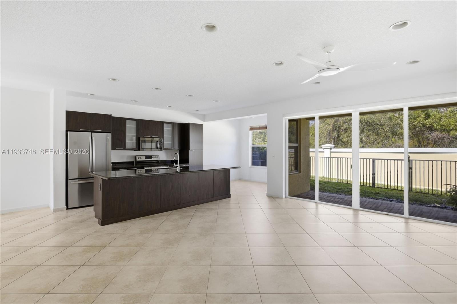 4857 Northwest 16th Terrace Boca Raton, FL 33431 - Photo 43 of 45 a large kitchen with kitchen island granite countertop a large window and stainless steel appliances