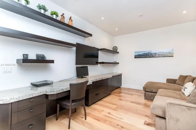 a bedroom with a bed a flat screen tv and a large window