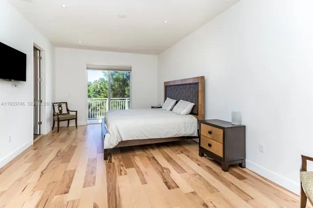 a bedroom with a bed tv and a window