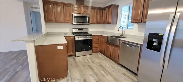 a kitchen with stainless steel appliances granite countertop a refrigerator a stove and a sink