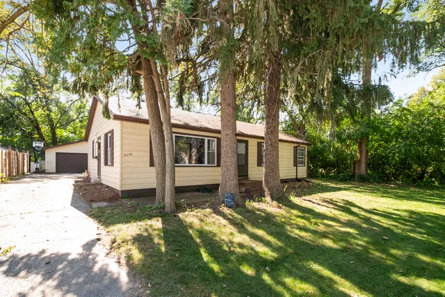 a white house that has a tree in front of it