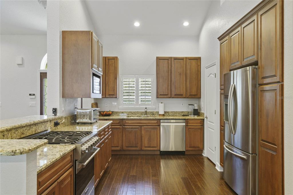 715 Magnolia Street Windermere, FL 34786 - Photo 13 of 44 a kitchen with stainless steel appliances granite countertop hardwood floor sink stove and refrigerator