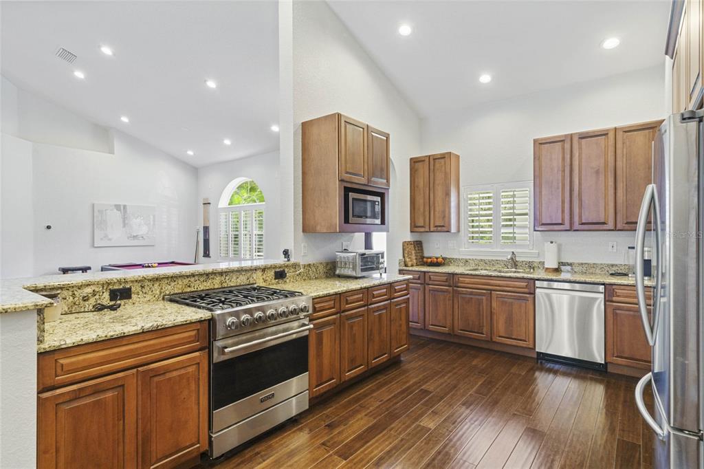 715 Magnolia Street Windermere, FL 34786 - Photo 14 of 44 a kitchen with stainless steel appliances granite countertop wooden cabinets stove and sink