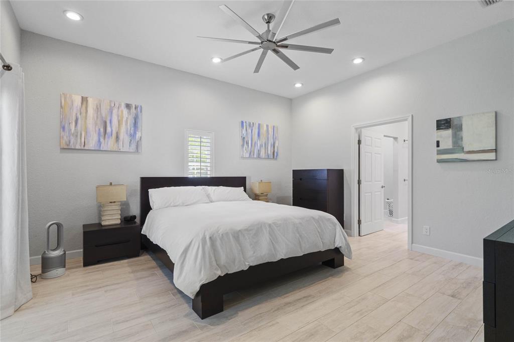 715 Magnolia Street Windermere, FL 34786 - Photo 23 of 44 a large bedroom with a bed and a chandelier