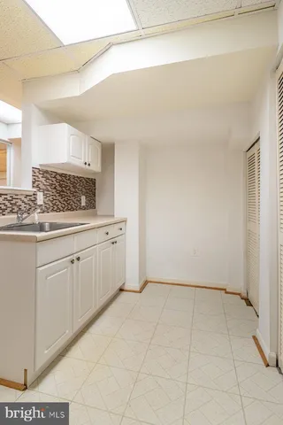 a view of a kitchen with white cabinets