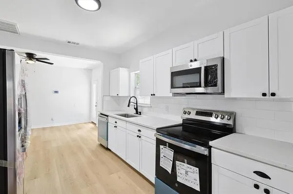 a kitchen with a sink stove and microwave