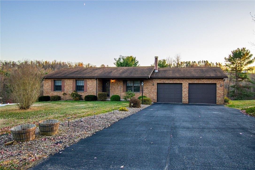 Ranch-style house with a garage and a front lawn