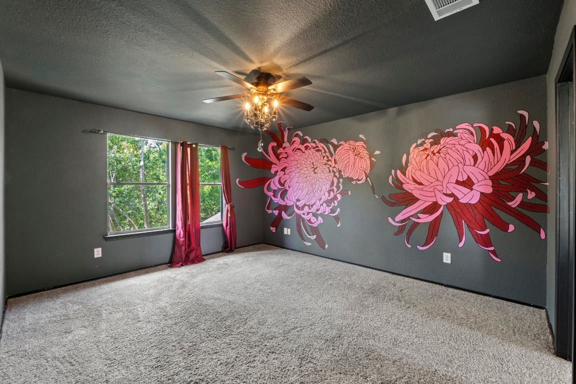 4608 Acers Lane Austin, TX 78725 - Photo 15 of 26 The roomy primary suite features a stylish light fixture/ceiling fan combo and a high ceiling.