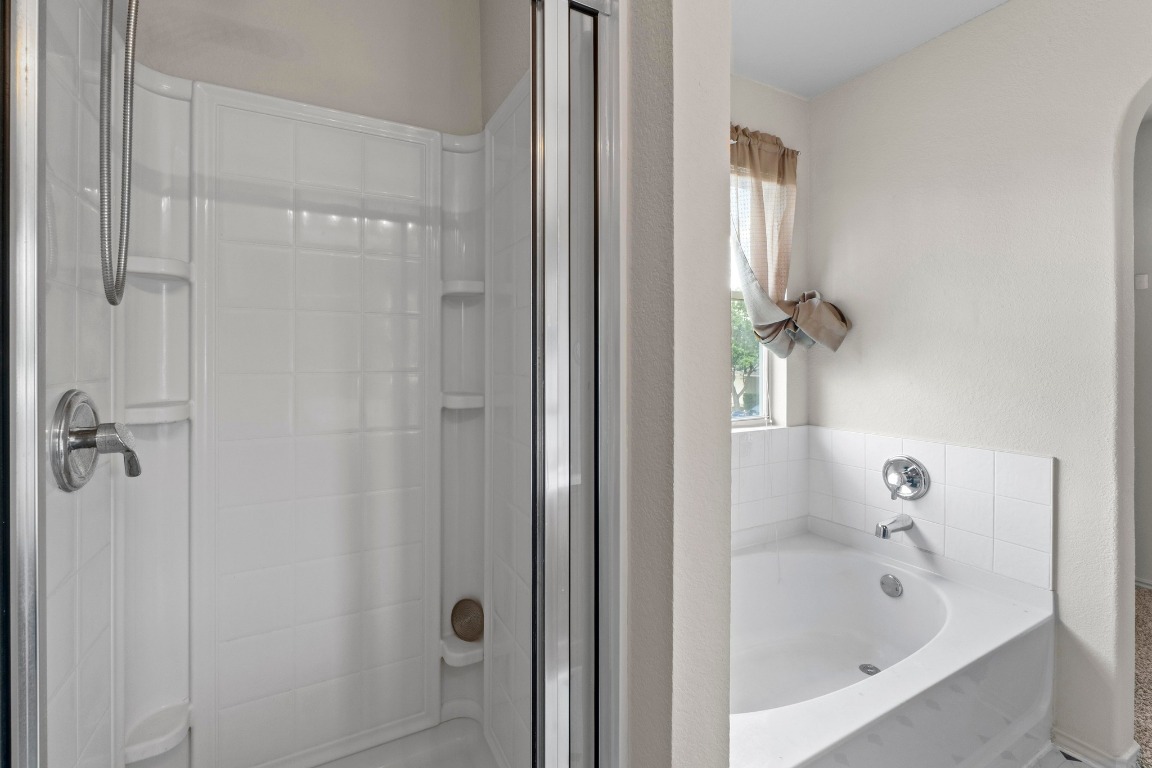 4608 Acers Lane Austin, TX 78725 - Photo 17 of 26 A look at the deep soaking tub and the walk-in shower.