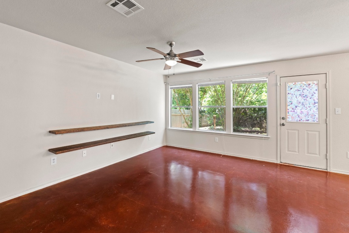 4608 Acers Lane Austin, TX 78725 - Photo 5 of 26 The living room includes a ceiling fan and several windows that help illuminate the space.