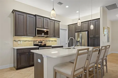 a kitchen with kitchen island a refrigerator stove microwave and cabinets
