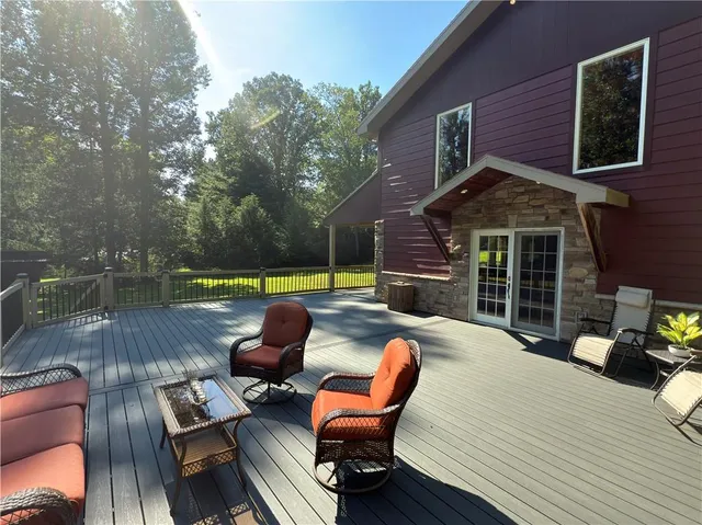 a view of a deck with couches table and chairs with wooden floor and fence