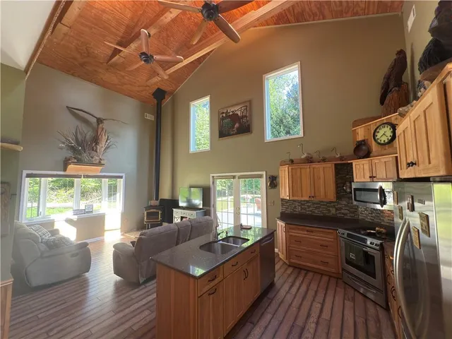 a kitchen with granite countertop a stove a sink and wooden floors