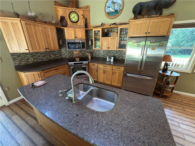 a bathroom with a glass door shower a sink and a toilet