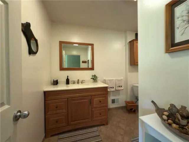 a bathroom with a sink a toilet a mirror and shower