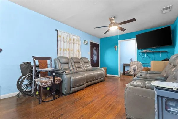 a living room with furniture a flat screen tv and a large window