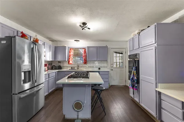 a kitchen with stainless steel appliances a refrigerator a stove a sink cabinets and a refrigerator