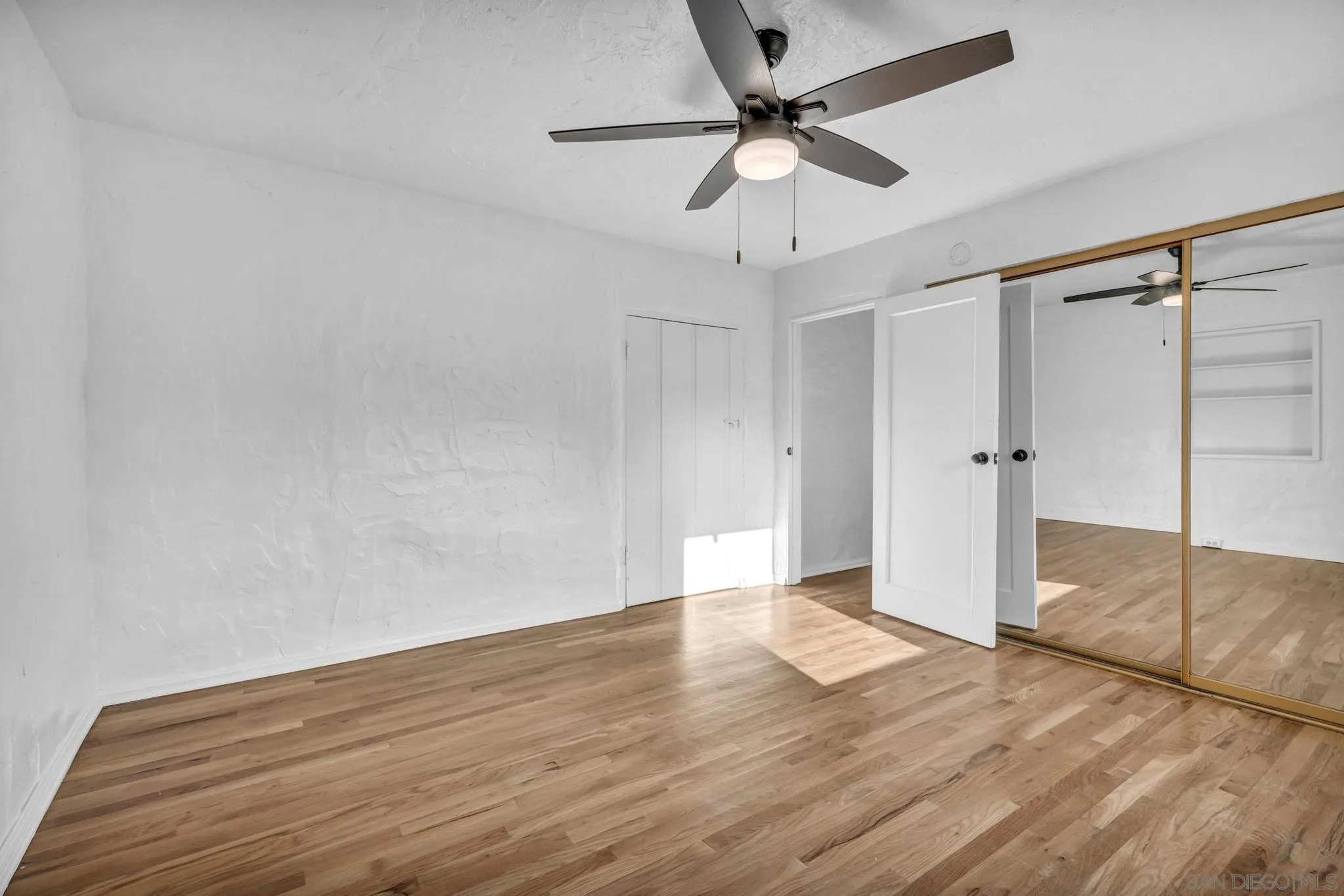 1230 Arnold Way Alpine, CA 91901 - Photo 23 of 60 an empty room with wooden floor and ceiling fan