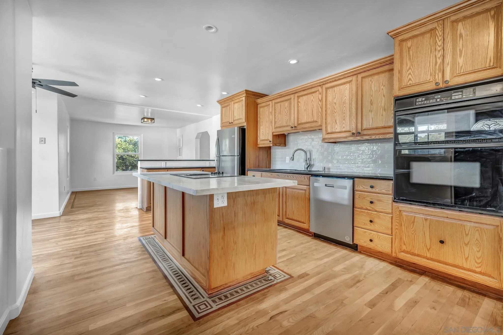 1230 Arnold Way Alpine, CA 91901 - Photo 9 of 60 a kitchen with stainless steel appliances granite countertop a stove top oven a sink dishwasher and a refrigerator with wooden floor