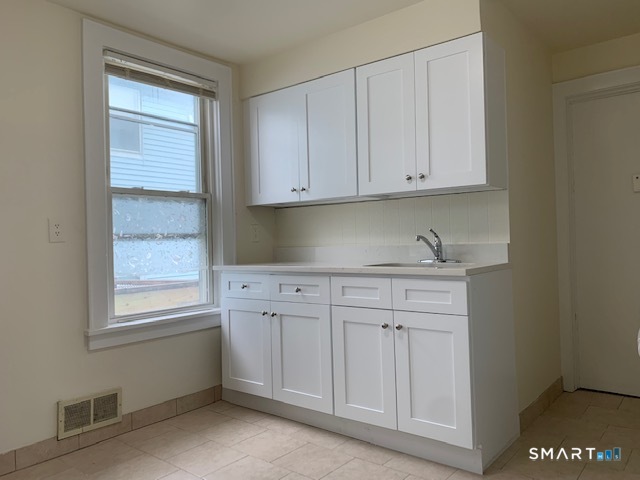 18 Lawrence Street Norwalk, CT 06854 - Photo 5 of 31 a kitchen with granite countertop white cabinets and sink