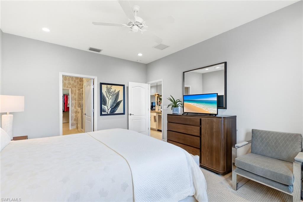 2311 Sawyers Hill Road, Unit 805 Naples, FL 34120 - Photo 14 of 27 a bedroom with a bed and a chandelier