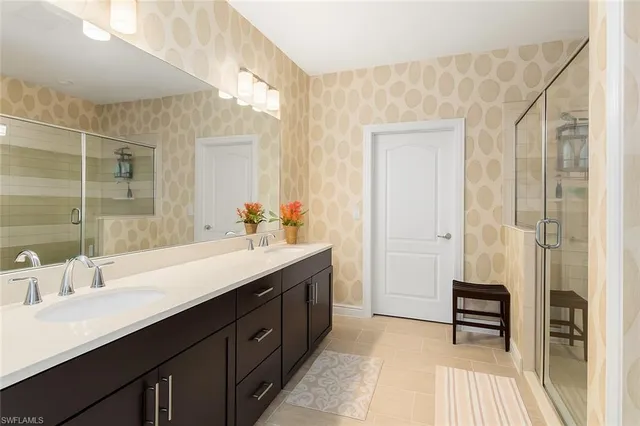 a spacious bathroom with a double vanity sink a mirror and a shower
