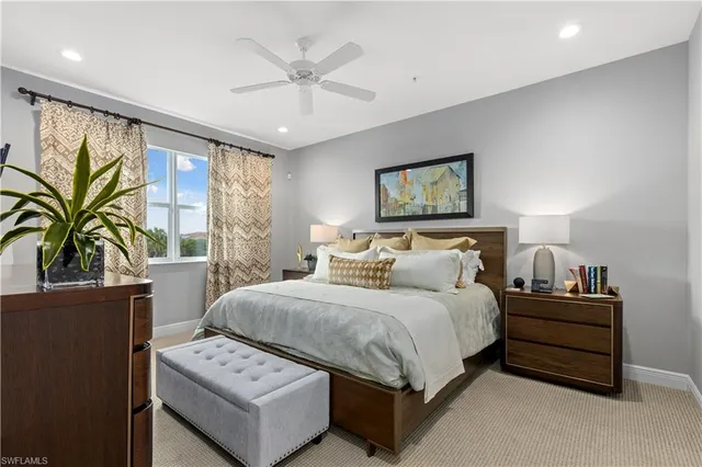 a spacious bedroom with a bed a couch and a large window