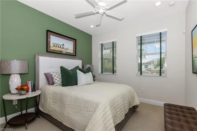 a bedroom with bed and a lamp on dresser