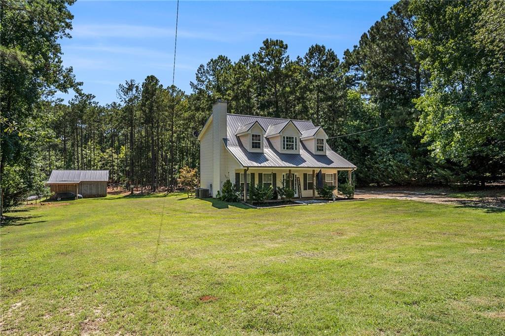 23 Erskine Road Monticello, GA 31064 - Photo 35 of 38 a yellow and white house with a big yard plants and large trees
