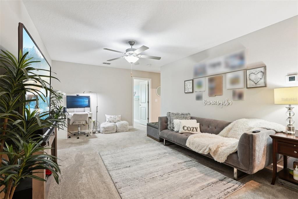 1306 White Fox Run Lutz, FL 33549 - Photo 18 of 35 a bedroom with a large bed and a chandelier