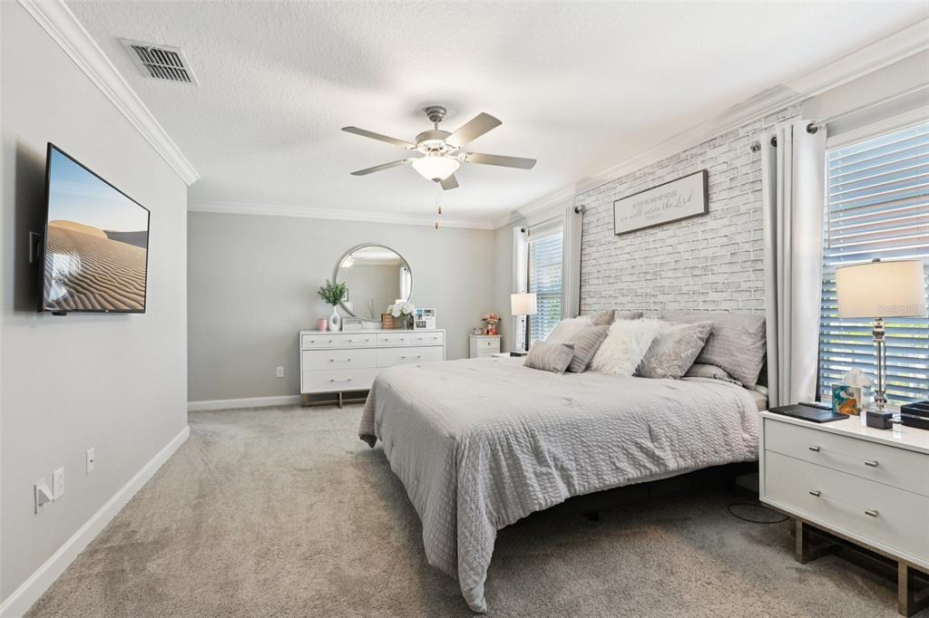 1306 White Fox Run Lutz, FL 33549 - Photo 20 of 35 a bedroom with a large bed and a chandelier fan