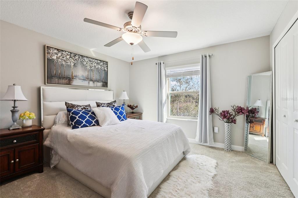 1306 White Fox Run Lutz, FL 33549 - Photo 23 of 35 a bedroom with a large bed and a chandelier