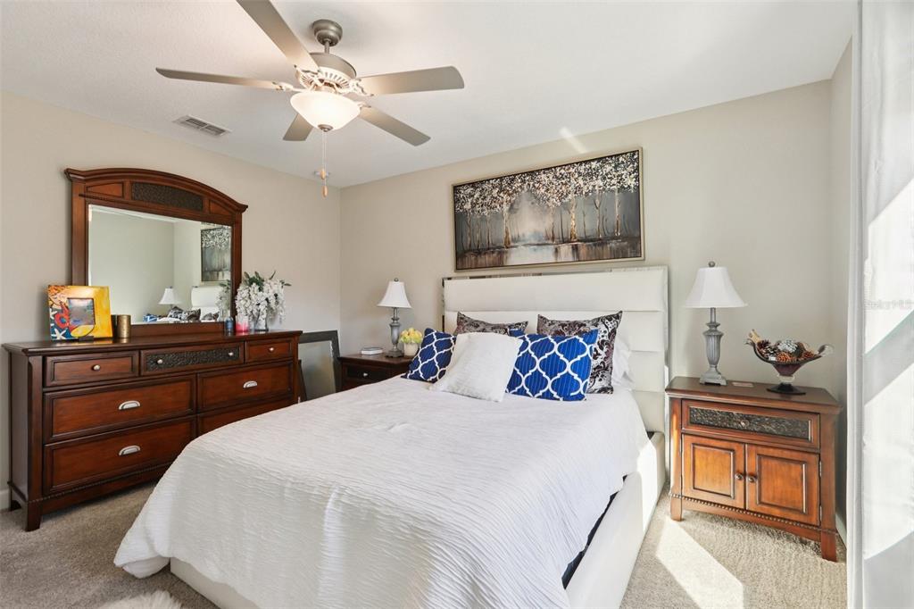 1306 White Fox Run Lutz, FL 33549 - Photo 24 of 35 a bedroom with a large bed and a chandelier