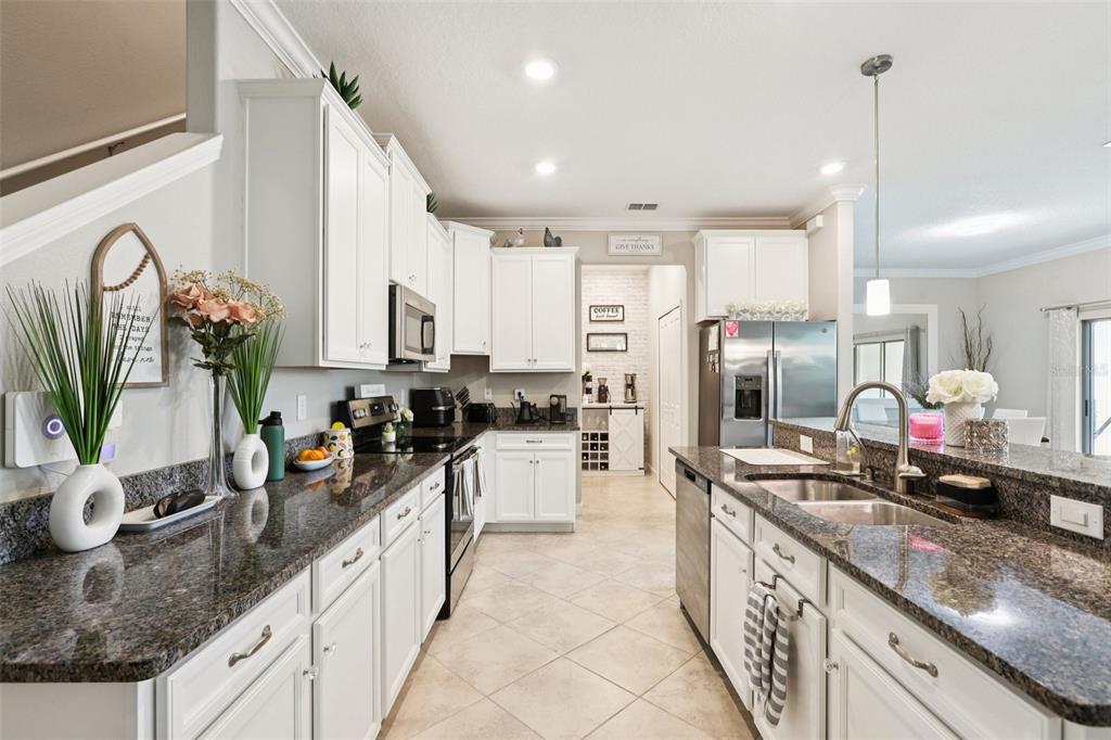 1306 White Fox Run Lutz, FL 33549 - Photo 8 of 35 a large kitchen with granite countertop a large counter top appliances and cabinets