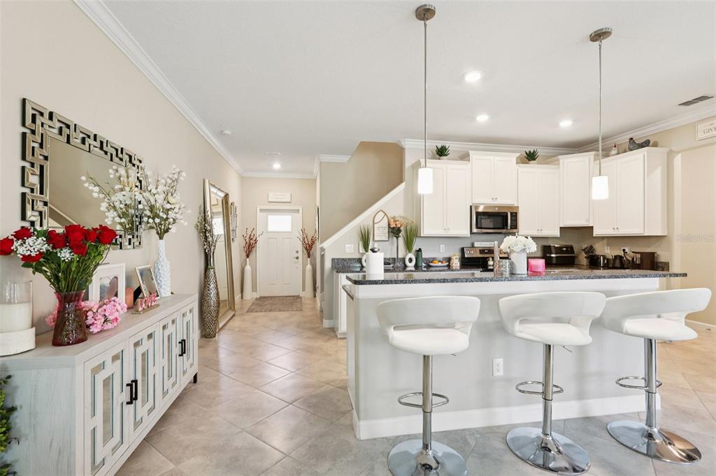 1306 White Fox Run Lutz, FL 33549 - Photo 9 of 35 a kitchen with stainless steel appliances kitchen island granite countertop a table chairs and white cabinets