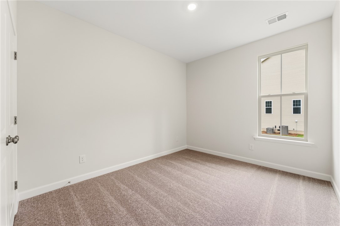 110 Lakeside Drive Anderson, SC 29621 - Photo 25 of 34 This spacious room features ample natural light and plush carpeting, offering a comfortable living space.
