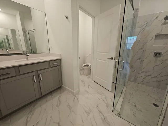 a bathroom with a double vanity sink toilet and shower