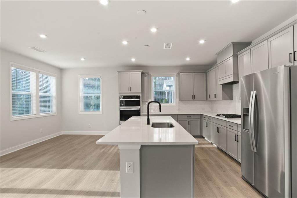 764 Clifftop Crossing Southwest Powder Springs, GA 30127 - Photo 11 of 38 a kitchen with refrigerator cabinets and wooden floor