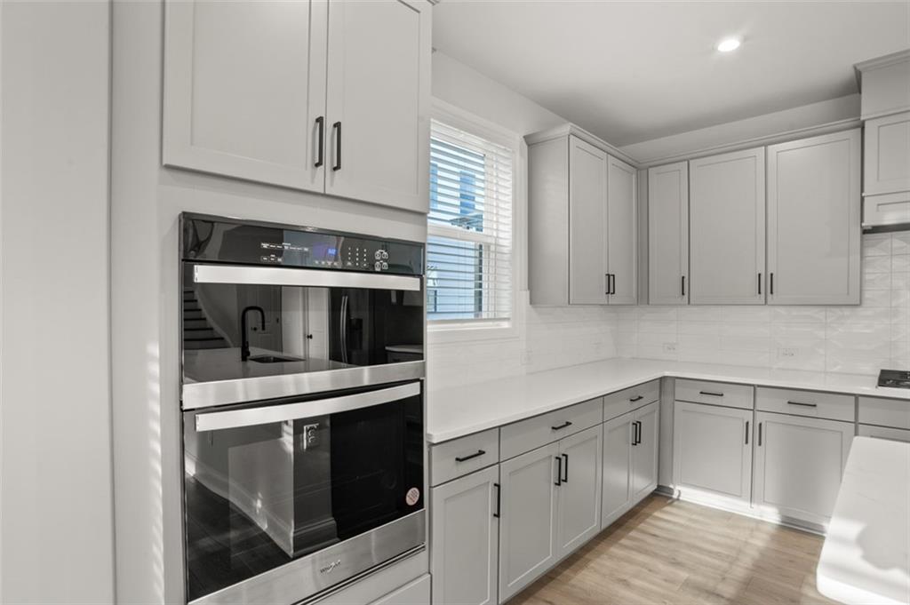 764 Clifftop Crossing Southwest Powder Springs, GA 30127 - Photo 16 of 38 a kitchen with white cabinets and stainless steel appliances