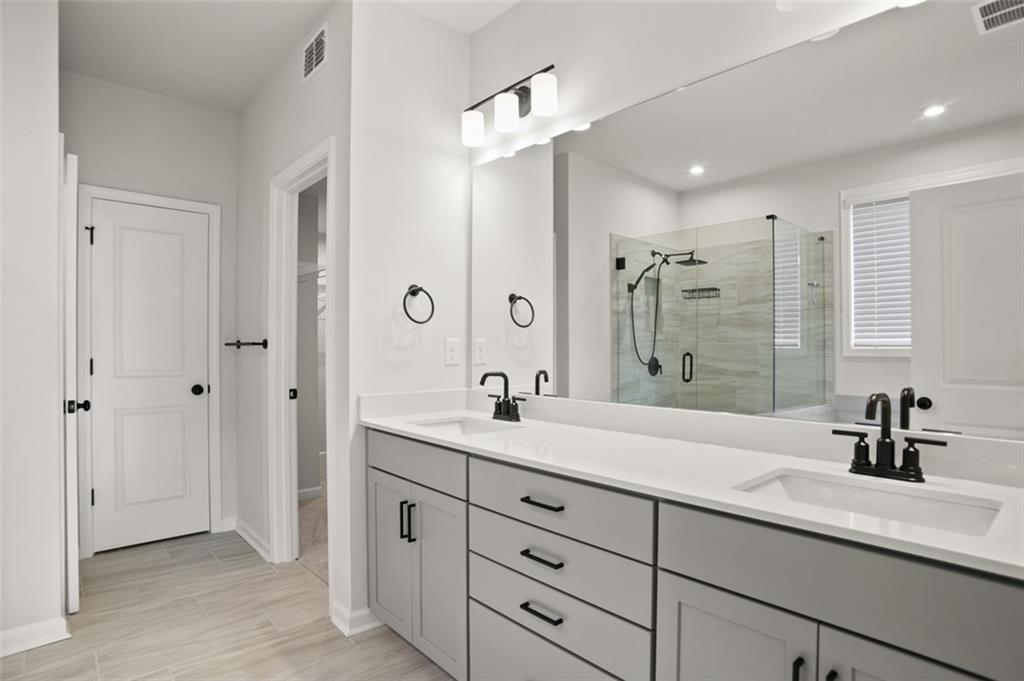 764 Clifftop Crossing Southwest Powder Springs, GA 30127 - Photo 27 of 38 a bath room with a sink double vanity granite tub shower and a mirror