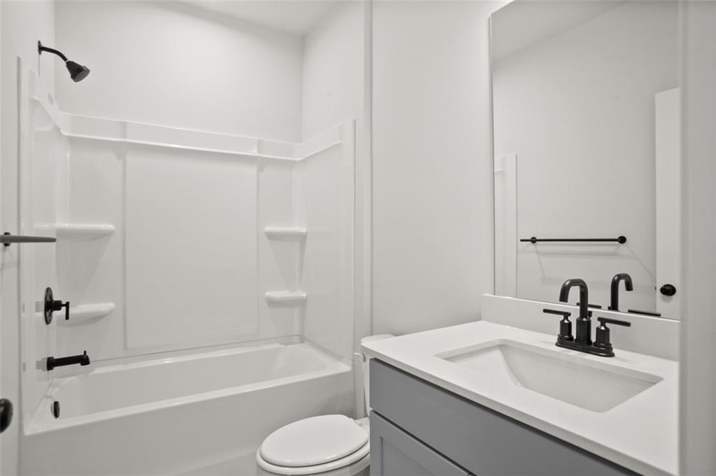 764 Clifftop Crossing Southwest Powder Springs, GA 30127 - Photo 30 of 38 a bathroom with a granite countertop sink toilet and shower