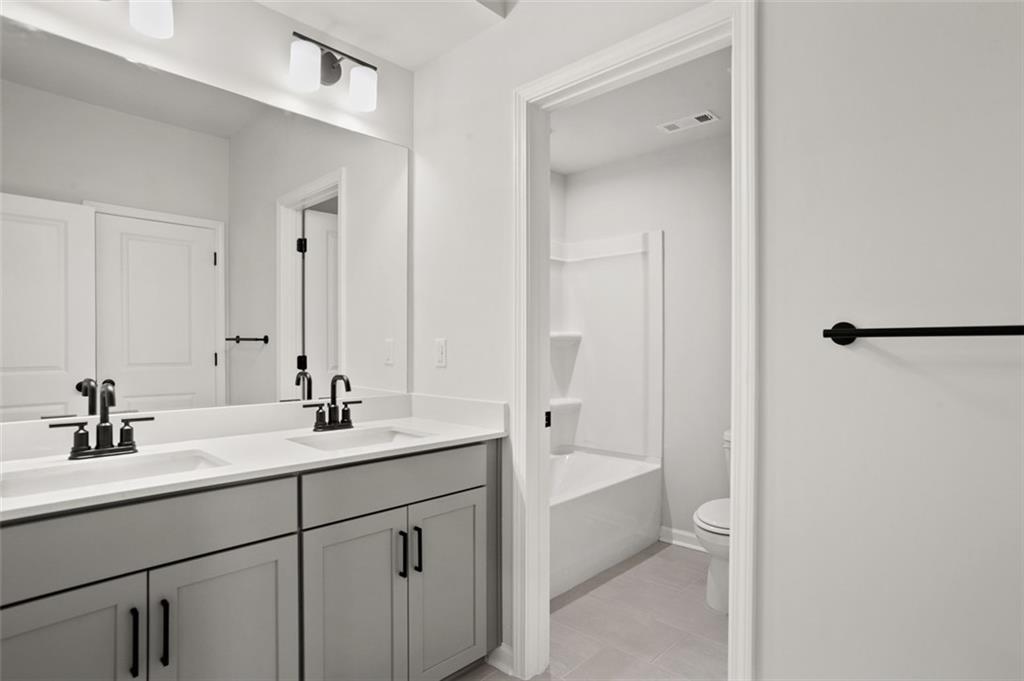 764 Clifftop Crossing Southwest Powder Springs, GA 30127 - Photo 32 of 38 a bathroom with a sink a toilet and shower
