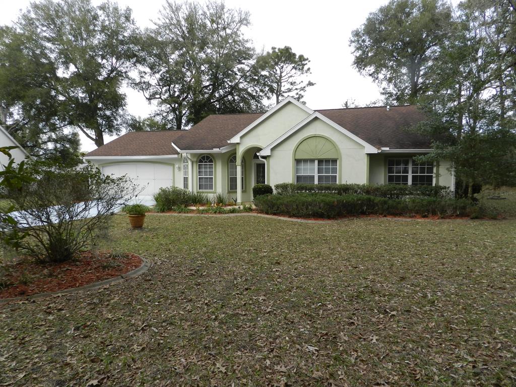 7465 Southwest 113th Place Ocala, FL 34476 - Photo 1 of 1 a front view of a house with a garden