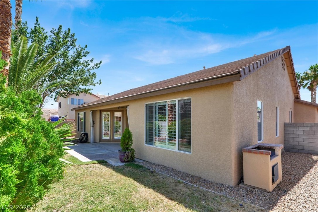 7308 Rustic Meadow Street Las Vegas, NV 89131 - Photo 25 of 27 A private backyard oasis featuring a paved patio and lush landscaping.