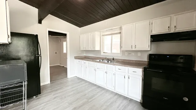 a kitchen with granite countertop a refrigerator sink and cabinets