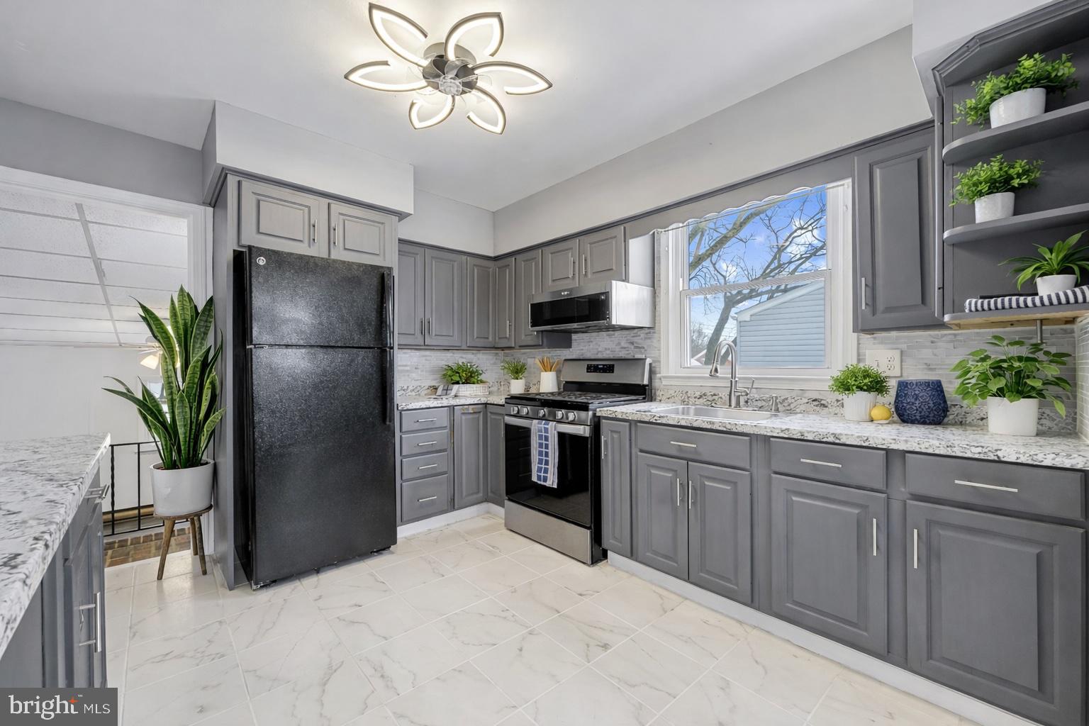911 Homberg Avenue Baltimore, MD 21221 - Photo 4 of 28 a kitchen with a refrigerator a stove a sink and a oven